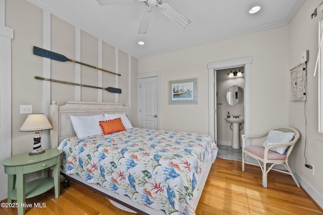 4248 Island Dr, North Topsail Beach, NC 28460 - bedroom featuring light wood-style flooring, ornamental molding, recessed lighting, baseboards, and a sink