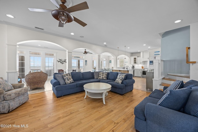 4248 Island Dr, North Topsail Beach, NC 28460 - living room with a ceiling fan, arched walkways, decorative columns, light wood-style floors, and recessed lighting