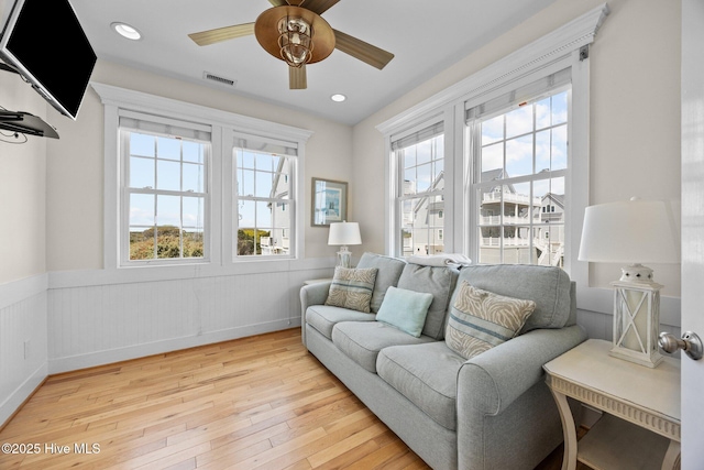 4248 Island Dr, North Topsail Beach, NC 28460 - living room with wainscoting, healthy amount of natural light, light wood-style floors, ceiling fan, and recessed lighting