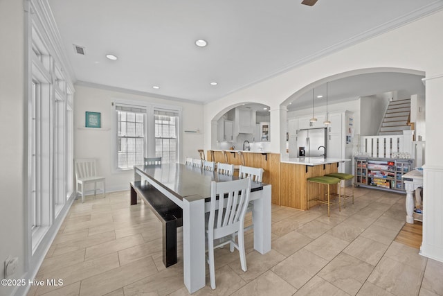 4248 Island Dr, North Topsail Beach, NC 28460 - dining area featuring crown molding, arched walkways, and recessed lighting