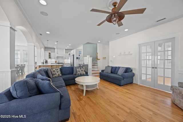 4248 Island Dr, North Topsail Beach, NC 28460 - living room with ornamental molding, ceiling fan, light wood finished floors, french doors, and stairs
