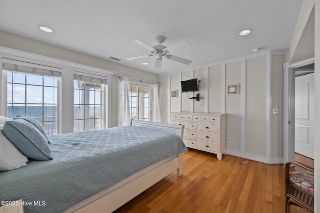 4248 Island Dr, North Topsail Beach, NC 28460 - bedroom with light wood finished floors, baseboards, recessed lighting, ceiling fan, and a water view