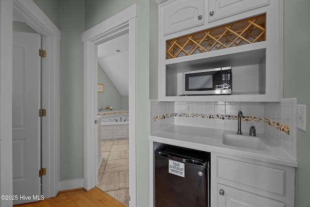 4248 Island Dr, North Topsail Beach, NC 28460 - kitchen featuring black dishwasher, white cabinetry, stainless steel microwave, a sink, and light countertops