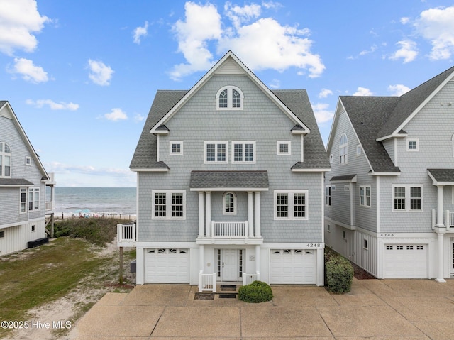 4248 Island Dr, North Topsail Beach, NC 28460 - shingle-style home with a water view, driveway, an attached garage, roof with shingles, and a balcony