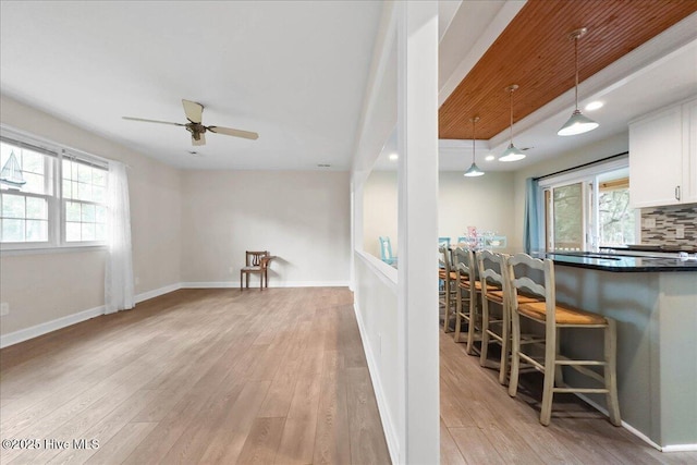 302 Mcglamery St, Oak Island, NC 28465 - kitchen featuring light wood finished floors, dark countertops, plenty of natural light, a kitchen breakfast bar, and recessed lighting