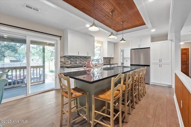 302 Mcglamery St, Oak Island, NC 28465 - kitchen with freestanding refrigerator, a raised ceiling, light wood-style flooring, wooden ceiling, and white cabinets