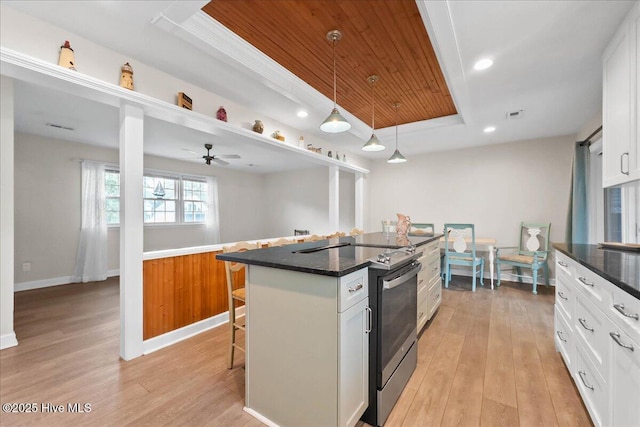 302 Mcglamery St, Oak Island, NC 28465 - kitchen with a raised ceiling, a kitchen breakfast bar, light wood-style flooring, white cabinets, and wood ceiling
