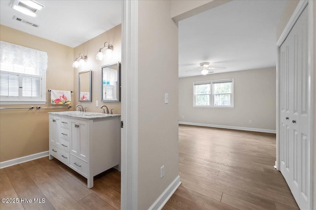 302 Mcglamery St, Oak Island, NC 28465 - bathroom featuring hardwood / wood-style flooring, vanity, ceiling fan, and baseboards