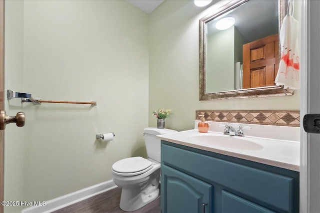 302 Mcglamery St, Oak Island, NC 28465 - bathroom with vanity, toilet, baseboards, wood finished floors, and backsplash