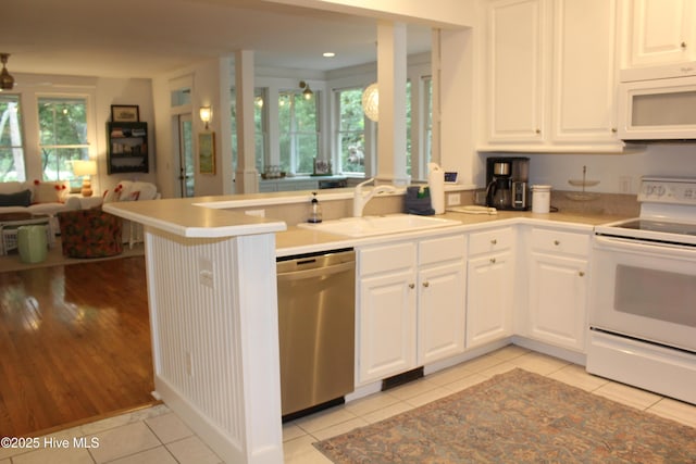19 Sabal Palm Trl, Bald Head Island, NC 28461 - kitchen with white appliances, open floor plan, a peninsula, white cabinetry, and recessed lighting