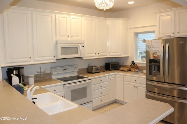 19 Sabal Palm Trl, Bald Head Island, NC 28461 - kitchen featuring white appliances, white cabinets, recessed lighting, a chandelier, and light countertops