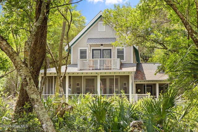 19 Sabal Palm Trl, Bald Head Island, NC 28461 - view of front of house with a sunroom, a balcony, and roof with shingles