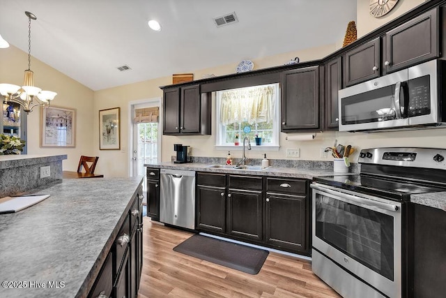 235 Chambers St, Winnabow, NC 28479 - kitchen featuring appliances with stainless steel finishes, a sink, lofted ceiling, a chandelier, and light wood-style flooring