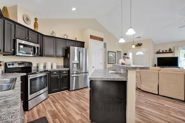 235 Chambers St, Winnabow, NC 28479 - kitchen featuring stainless steel appliances, open floor plan, light wood-type flooring, a kitchen bar, and light countertops