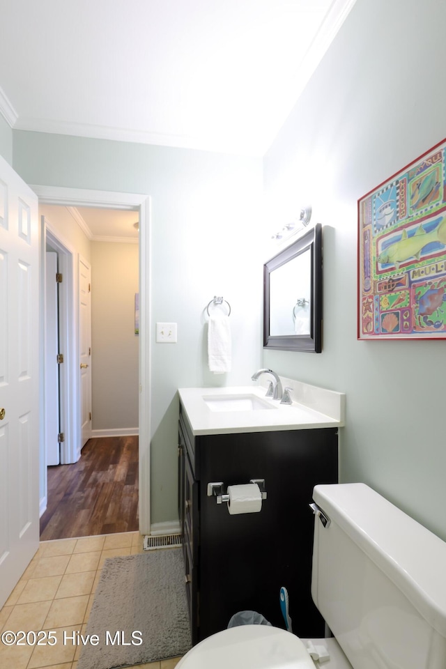 1116 E Ft Macon Rd, Atlantic Beach, NC 28512 - half bathroom featuring crown molding, toilet, vanity, tile patterned floors, and baseboards