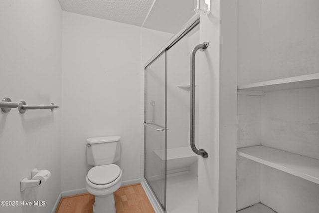304 Lord Granville Dr, Morehead City, NC 28557 - bathroom featuring a shower stall, wood finished floors, toilet, and a textured ceiling