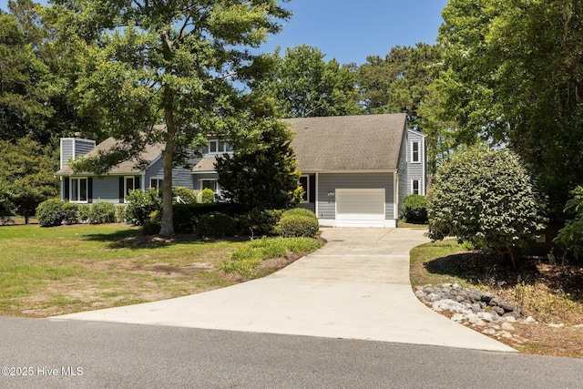 304 Lord Granville Dr, Morehead City, NC 28557 - obstructed view of property with concrete driveway, a chimney, an attached garage, a front lawn, and a shingled roof