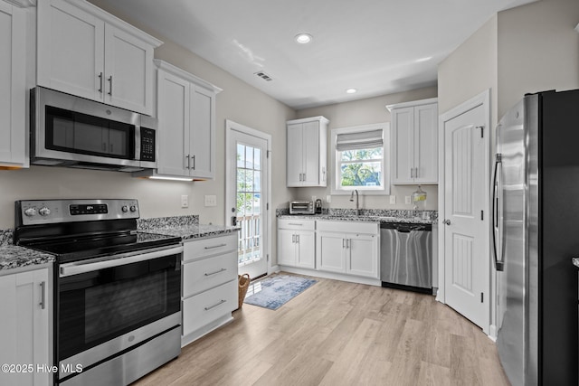 104 S 30th St, Morehead City, NC 28557 - kitchen with stainless steel appliances, recessed lighting, light wood finished floors, and white cabinets