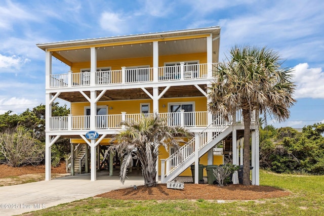 2414 Ocean Dr, Emerald Isle, NC 28594 - coastal inspired home featuring a carport, a porch, stairway, driveway, and a balcony