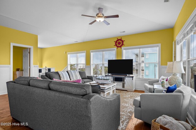 2414 Ocean Dr, Emerald Isle, NC 28594 - living area featuring lofted ceiling, light wood-type flooring, healthy amount of natural light, ceiling fan, and a wainscoted wall
