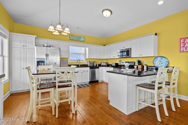 2414 Ocean Dr, Emerald Isle, NC 28594 - kitchen featuring stainless steel appliances, a peninsula, white cabinetry, light wood-style floors, and recessed lighting
