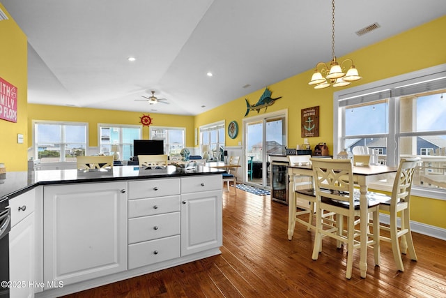 2414 Ocean Dr, Emerald Isle, NC 28594 - kitchen featuring a chandelier, dark wood-style floors, a ceiling fan, dark countertops, and white cabinetry