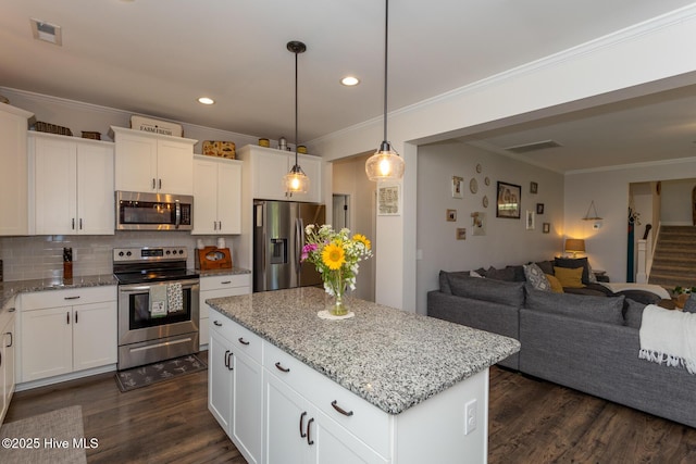 111 Pinelands Vis, Jackson Springs, NC 27281 - kitchen featuring appliances with stainless steel finishes, open floor plan, dark wood-style flooring, a center island, and ornamental molding