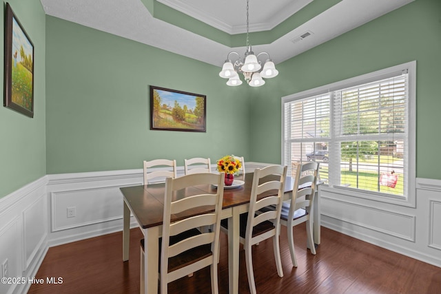 3412 Lefringhouse Ln, New Bern, NC 28562 - dining room with crown molding, a chandelier, dark wood-type flooring, a wainscoted wall, and a tray ceiling