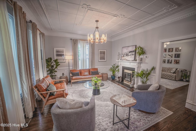 1309 N Pasteur St, New Bern, NC 28560 - living area featuring crown molding, a chandelier, a fireplace, dark wood-style floors, and a wainscoted wall