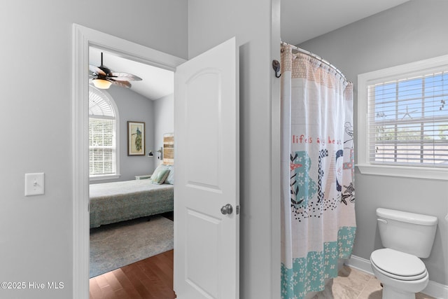 124 NE 35th St, Oak Island, NC 28465 - ensuite bathroom with ceiling fan, toilet, wood finished floors, baseboards, and a shower with curtain