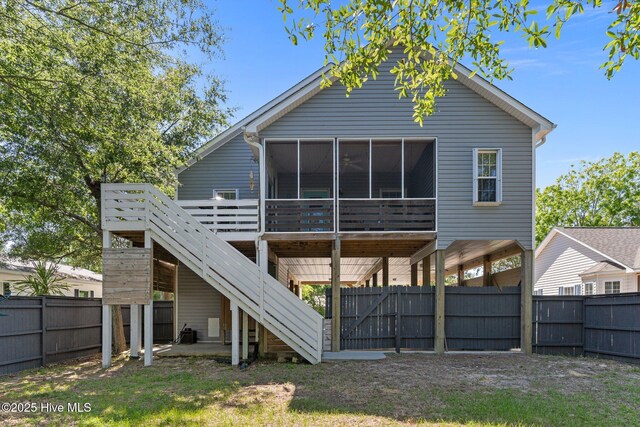 124 NE 35th St, Oak Island, NC 28465 - rear view of house featuring a sunroom, a fenced backyard, and stairway