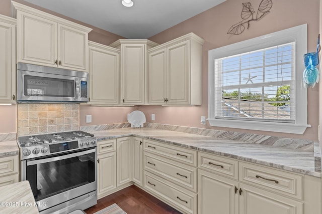 124 NE 35th St, Oak Island, NC 28465 - kitchen featuring appliances with stainless steel finishes, light stone countertops, dark wood-type flooring, and backsplash