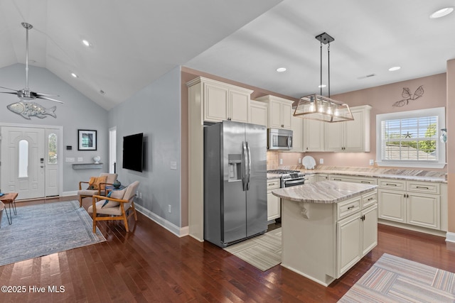 124 NE 35th St, Oak Island, NC 28465 - kitchen with stainless steel appliances, dark wood-type flooring, light stone countertops, a kitchen island, and baseboards