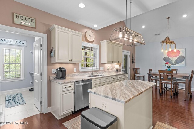 124 NE 35th St, Oak Island, NC 28465 - kitchen with a sink, stainless steel dishwasher, light stone counters, a center island, and baseboards