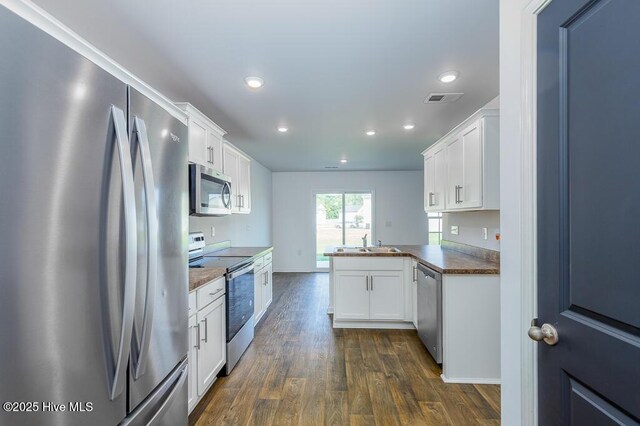 101 Jessica Ct, Vanceboro, NC 28586 - kitchen with appliances with stainless steel finishes, dark wood-style floors, recessed lighting, a sink, and white cabinetry