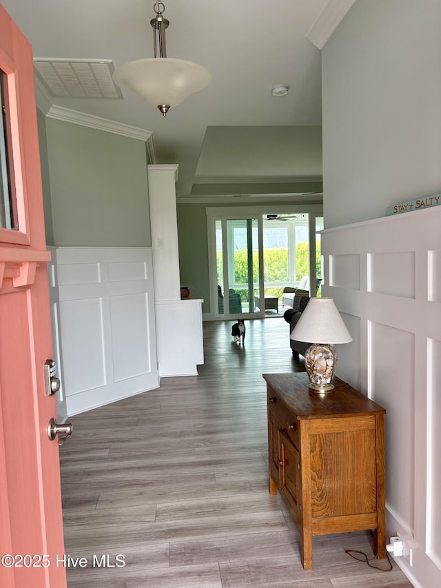 7000 Sevilleen Dr SW, Ocean Isle Beach, NC 28469 - entryway featuring crown molding, a decorative wall, ceiling fan, light wood-style floors, and wainscoting