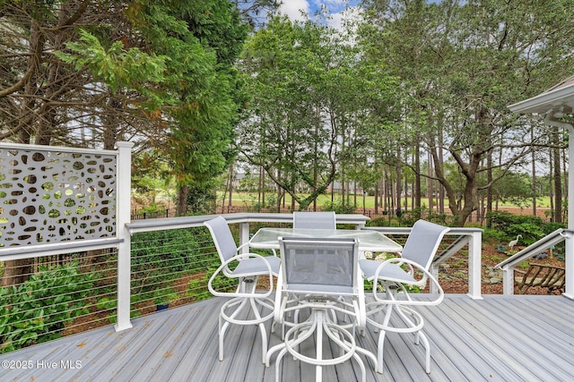 3193 Wexford Way, Southport, NC 28461 - wooden deck featuring outdoor dining space and view of scattered trees