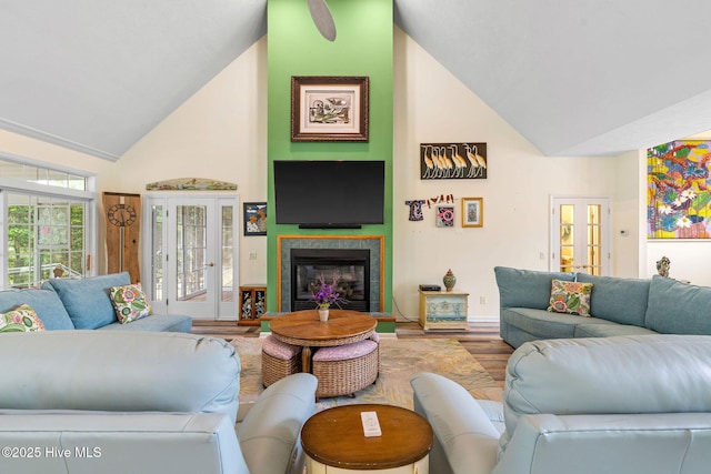 3193 Wexford Way, Southport, NC 28461 - living area featuring wood finished floors, high vaulted ceiling, a glass covered fireplace, and baseboards