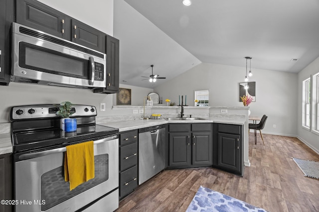 301 Haws Run Rd, Jacksonville, NC 28540 - kitchen featuring stainless steel appliances, a peninsula, a sink, lofted ceiling, and light countertops