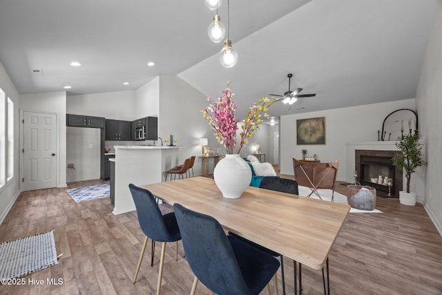 301 Haws Run Rd, Jacksonville, NC 28540 - dining space featuring vaulted ceiling, light wood-type flooring, ceiling fan, a premium fireplace, and baseboards