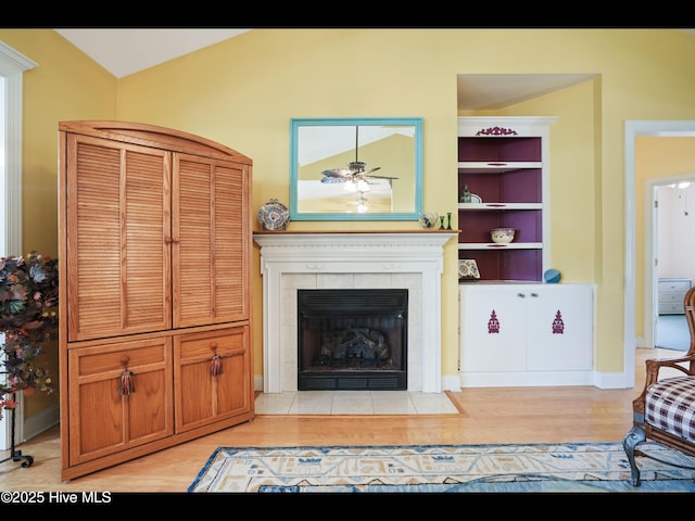 1133 Grandiflora Dr, Leland, NC 28451 - living room with light wood-style flooring, lofted ceiling, a tile fireplace, a ceiling fan, and baseboards