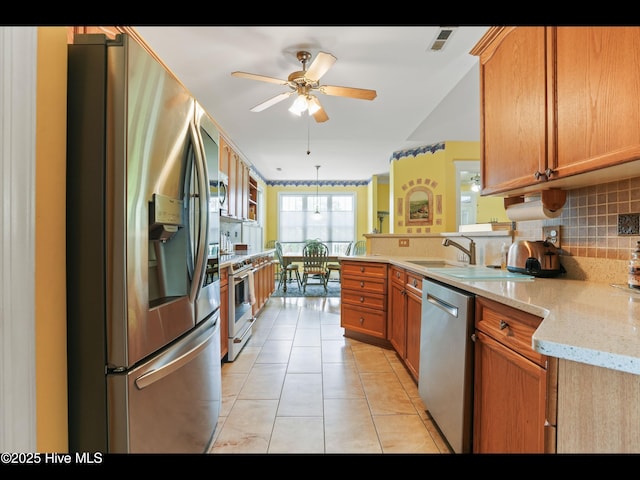1133 Grandiflora Dr, Leland, NC 28451 - kitchen with appliances with stainless steel finishes, backsplash, light tile patterned floors, a peninsula, and a ceiling fan