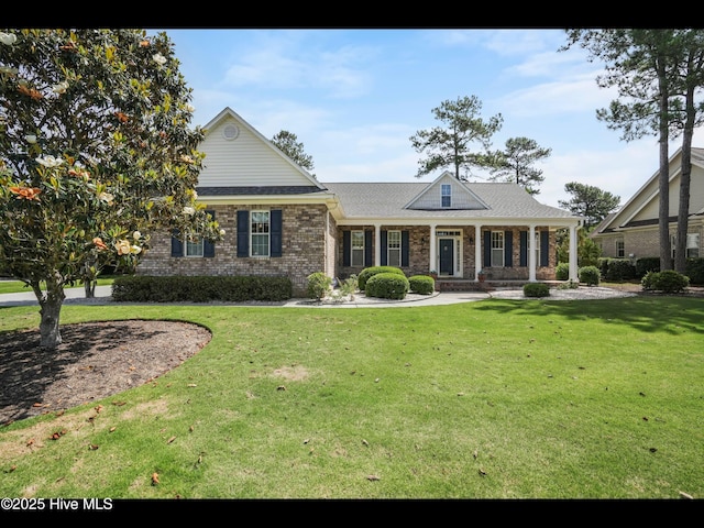 1133 Grandiflora Dr, Leland, NC 28451 - view of front facade featuring a front yard, covered porch, and brick siding