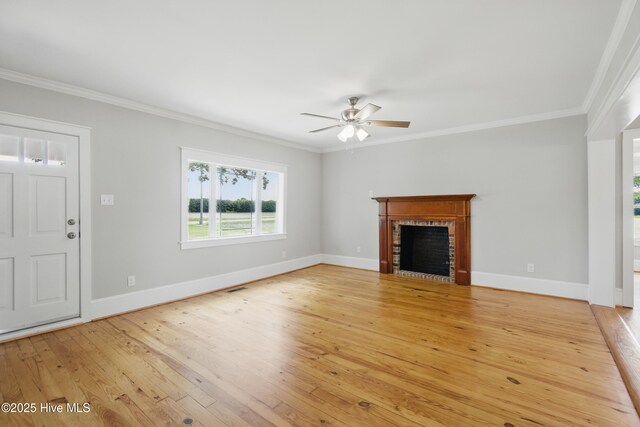 257 Evans-Bass Rd, Edenton, NC 27932 - unfurnished living room with a brick fireplace, crown molding, a ceiling fan, light wood-style floors, and baseboards