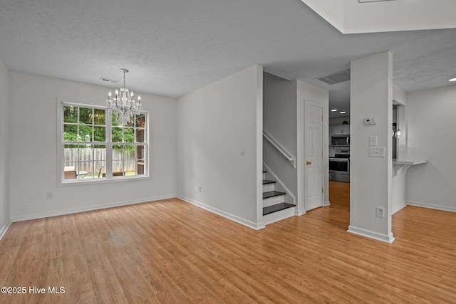 100 Hedingham Ct, Wilmington, NC 28412 - empty room featuring stairs, wood finished floors, baseboards, a chandelier, and a textured ceiling