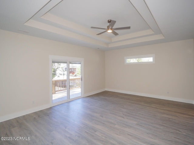 335 NE 41st St, Oak Island, NC 28465 - unfurnished room featuring a tray ceiling, a ceiling fan, wood finished floors, and baseboards
