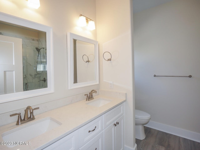 335 NE 41st St, Oak Island, NC 28465 - bathroom with toilet, double vanity, a shower, wood finished floors, and baseboards