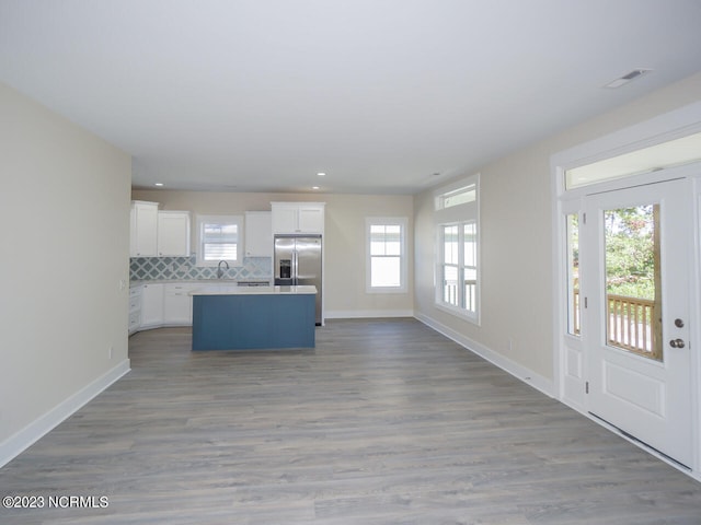 335 NE 41st St, Oak Island, NC 28465 - kitchen featuring stainless steel fridge with ice dispenser, open floor plan, a kitchen island, white cabinets, and baseboards