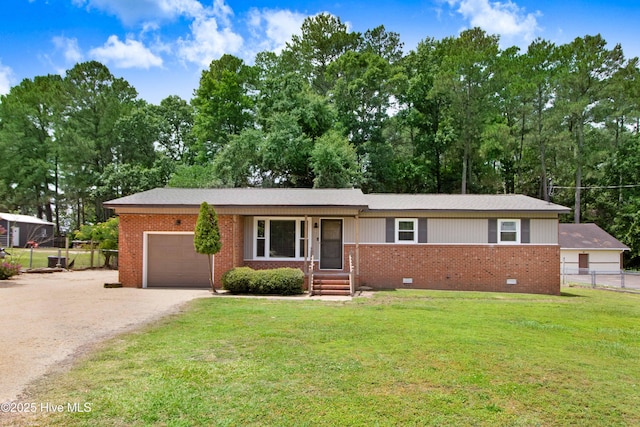 287 Perkins Rd, Goldsboro, NC 27530 - ranch-style house with an attached garage, driveway, brick siding, crawl space, and view of wooded area