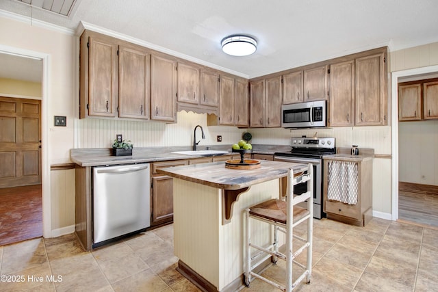 287 Perkins Rd, Goldsboro, NC 27530 - kitchen with appliances with stainless steel finishes, a sink, crown molding, a center island, and butcher block countertops